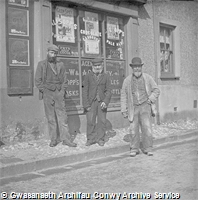 Tri gŵr bonheddig y tu allan i siop A I Williams / Three gentleman outside of A I Williams Corner Shop